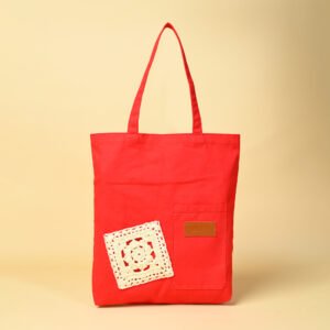 Red canvas tote bag with crochet patch